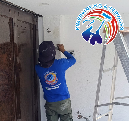 Pintor profesional revisando con linterna y odómetro el estado de un muro de casa antes de realizar presupuesto